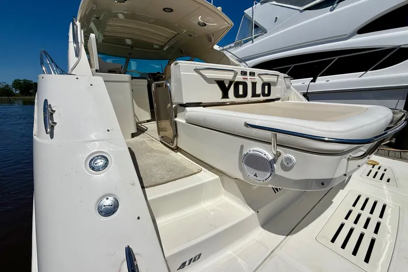 Slide: The Image of 2012 Sea Ray 410 Sundancer yacht with "YOLO" on the back, docked in sunlight. - 7