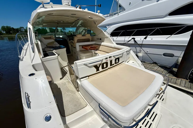 Slide: The Image of 2012 Sea Ray 410 Sundancer yacht docked, featuring spacious seating and sleek design. - 8
