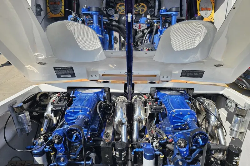 Slide: The Image of Engine compartment of a 2001 Cigarette 42' Tiger boat, showcasing dual blue engines. - 110
