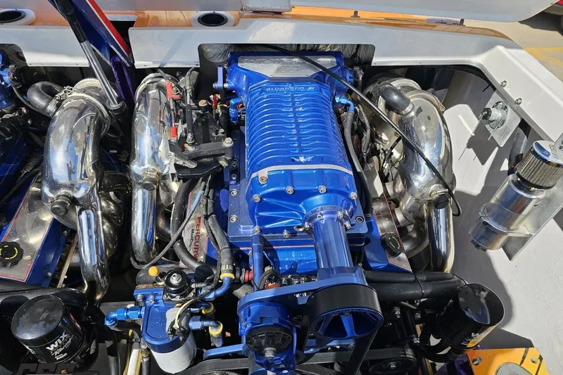 Slide: The Image of Engine of a 2001 Cigarette 42' Tiger boat, featuring a blue supercharger and chrome components. - 114