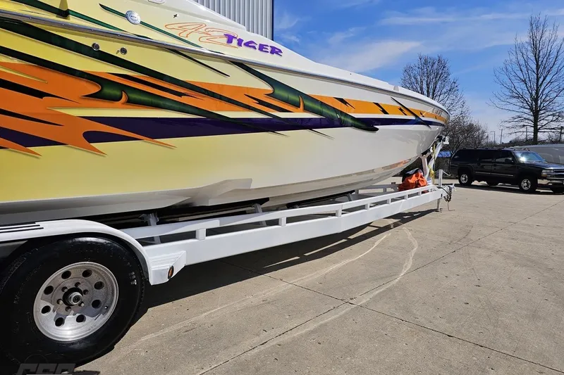 Slide: The Image of 2001 Cigarette 42' Tiger boat with vibrant graphics on a trailer. - 12