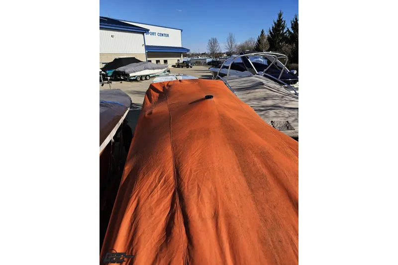 Slide: The Image of 2001 Cigarette 42' Tiger boat covered with orange tarp at a sport center. - 124