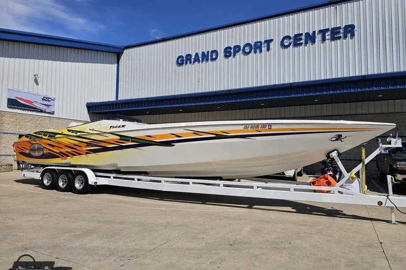 Slide: The Image of 2001 Cigarette 42' Tiger boat with vibrant graphics at Grand Sport Center. - 15