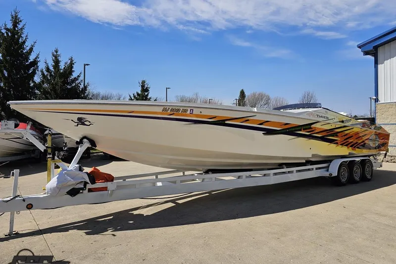 Slide: The Image of 2001 Cigarette 42' Tiger powerboat on trailer, vibrant graphics, parked outdoors. - 18