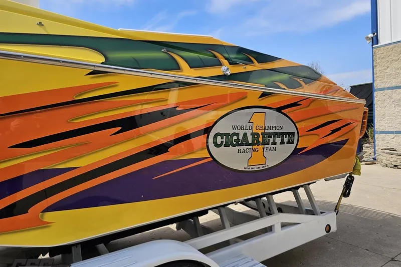 Slide: The Image of 2001 Cigarette 42' Tiger boat with vibrant racing graphics on a trailer. - 25