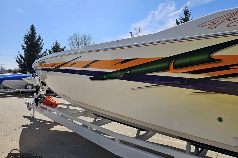 Slide: The Image of 2001 Cigarette 42' Tiger boat with vibrant graphics on a trailer. - 27