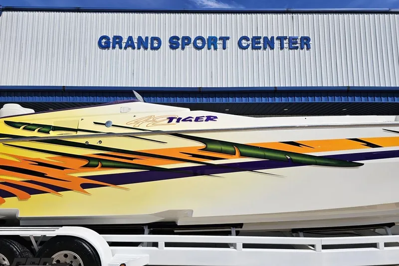Slide: The Image of 2001 Cigarette 42' Tiger boat with vibrant graphics at Grand Sport Center. - 3