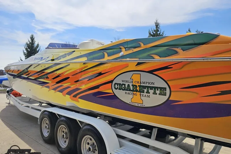Slide: The Image of 2001 Cigarette 42' Tiger powerboat with vibrant racing graphics on a trailer. - 31