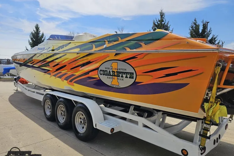Slide: The Image of 2001 Cigarette 42' Tiger boat with vibrant flame design on trailer. - 32