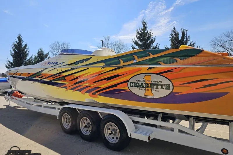 Slide: The Image of 2001 Cigarette 42' Tiger boat with vibrant racing design on trailer. - 33