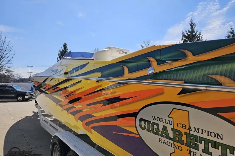 Slide: The Image of 2001 Cigarette 42' Tiger boat with vibrant racing graphics on a trailer. - 35