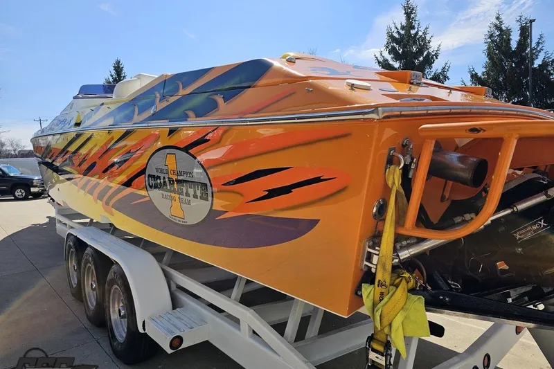 Slide: The Image of 2001 Cigarette 42' Tiger speedboat with vibrant orange and yellow racing design on trailer. - 36