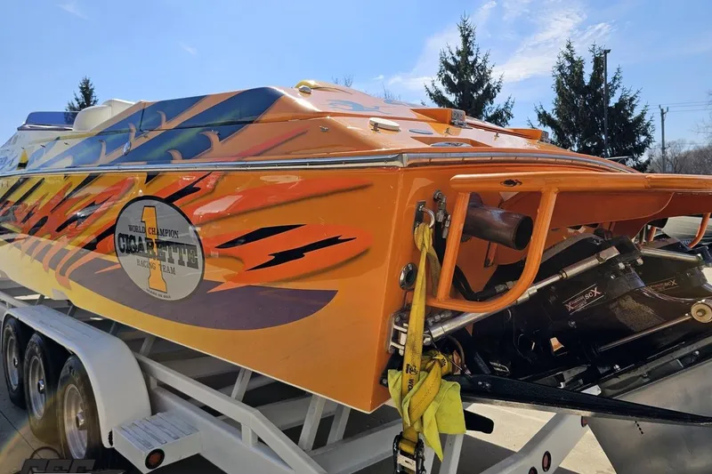 Slide: The Image of 2001 Cigarette 42' Tiger boat with vibrant orange and blue racing design on trailer. - 37