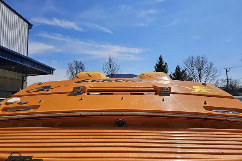 Slide: The Image of Orange 2001 Cigarette 42' Tiger boat with decals, under a clear blue sky. - 40