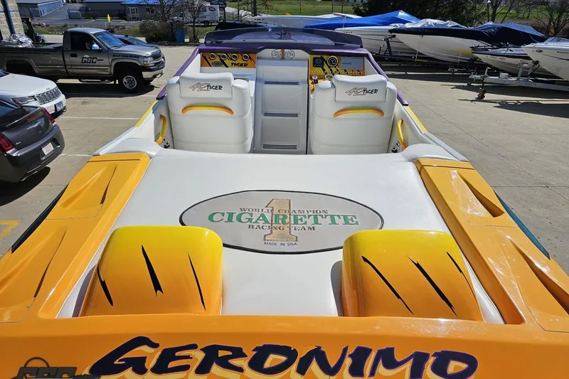 Slide: The Image of 2001 Cigarette 42' Tiger boat with vibrant yellow and white design, parked outdoors. - 49