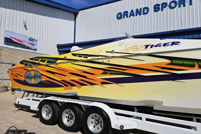 Slide: The Image of 2001 Cigarette 42' Tiger powerboat with vibrant graphics on a trailer at Grand Sport facility. - 5
