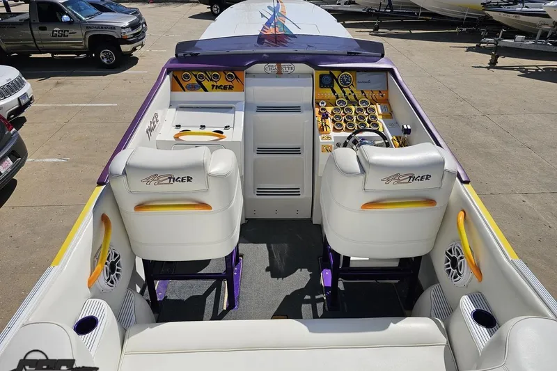 Slide: The Image of 2001 Cigarette 42' Tiger boat interior with white seats and vibrant dashboard. - 55