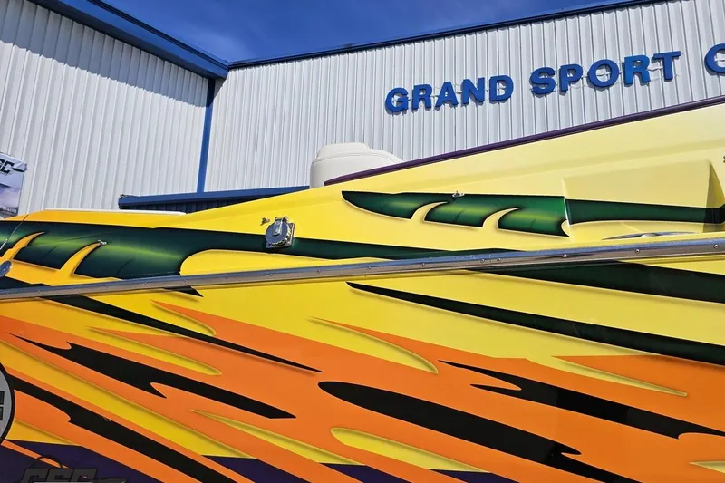 Slide: The Image of Colorful 2001 Cigarette 42' Tiger boat with vibrant graphics at Grand Sport Center. - 6