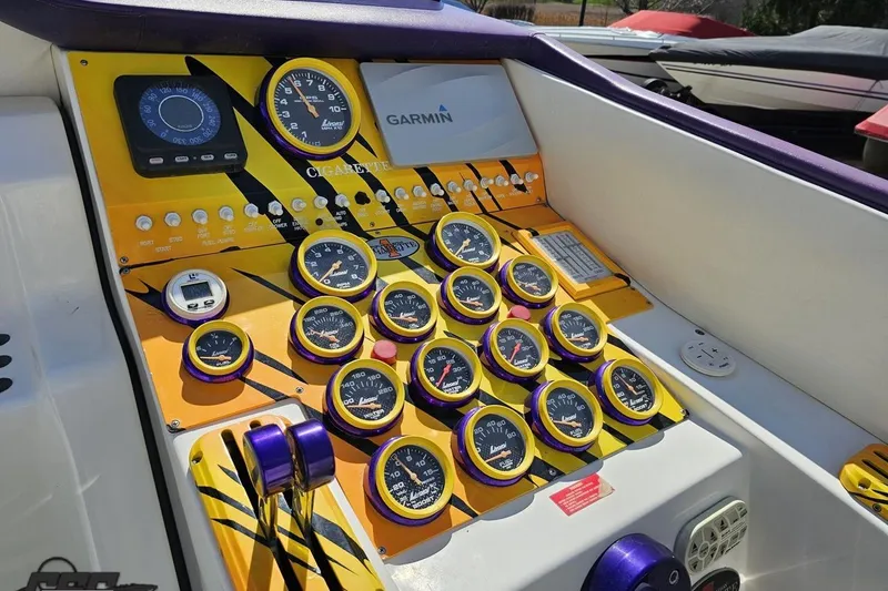Slide: The Image of Dashboard of a 2001 Cigarette 42' Tiger boat with vibrant gauges and Garmin navigation. - 67