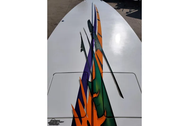 Slide: The Image of 2001 Cigarette 42' Tiger boat with vibrant orange, green, and purple graphics on deck. - 78