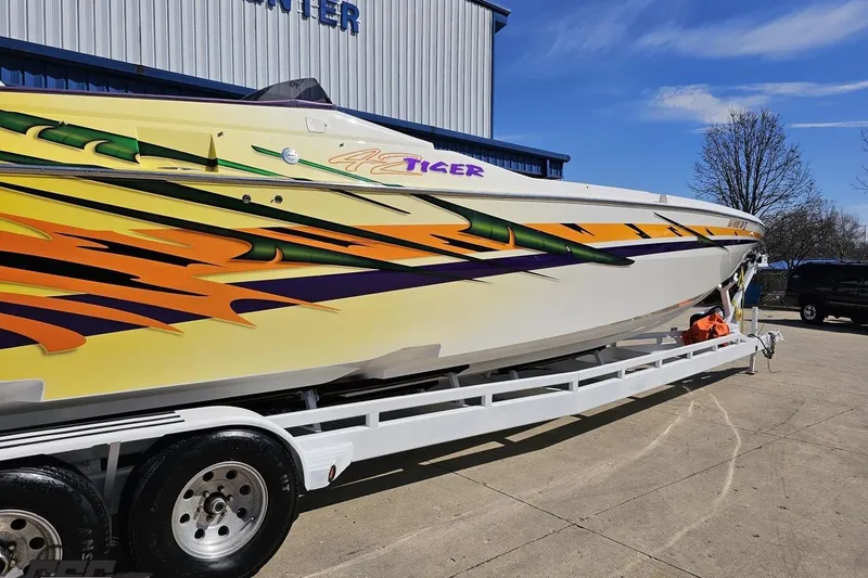 Slide: The Image of 2001 Cigarette 42' Tiger boat with vibrant graphics on a trailer. - 8