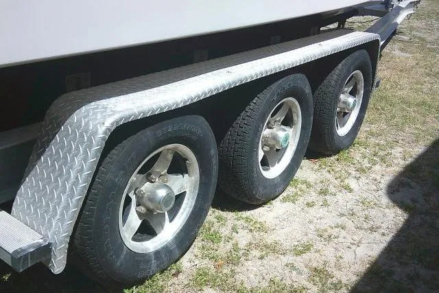 Slide: The Image of Triple-axle trailer for 2000 Grady-White Sailfish 272 boat on grassy surface. - 12
