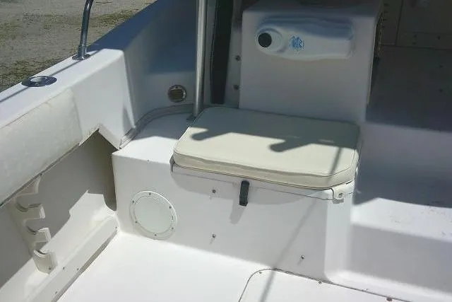 Slide: The Image of 2000 Grady-White Sailfish 272 boat interior with cushioned seating and storage compartment. - 18