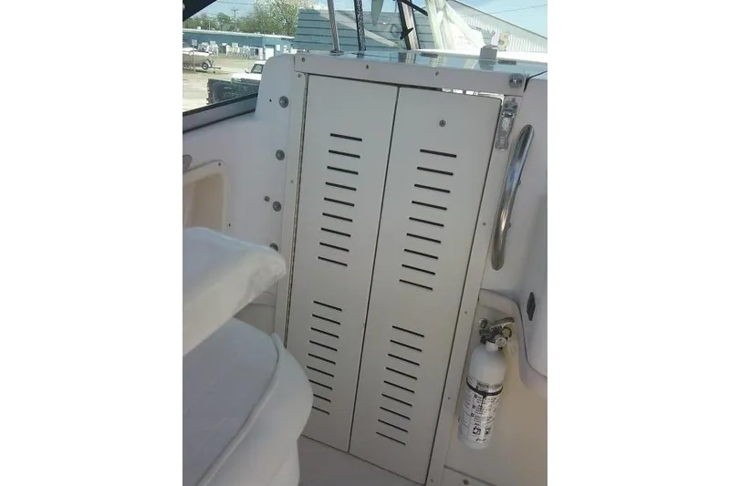 Slide: The Image of Interior view of a 2000 Grady-White Sailfish 272 boat, featuring a storage compartment and fire extinguisher. - 29