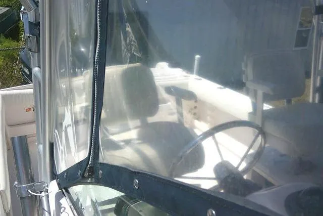 Slide: The Image of 2000 Grady-White Sailfish 272 boat interior with steering wheel and seating visible through clear enclosure. - 54