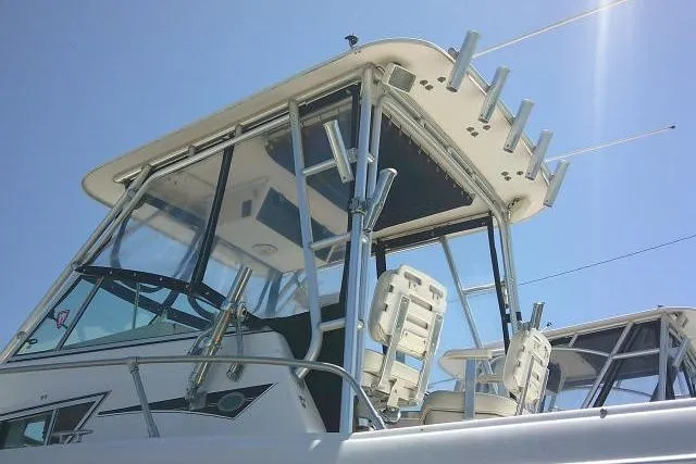 Slide: The Image of 2000 Grady-White Sailfish 272 boat with T-top and rod holders under clear blue sky. - 57