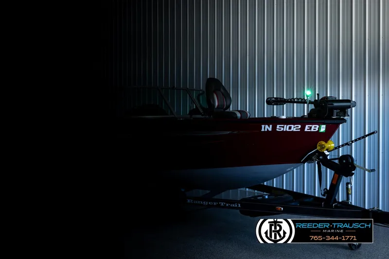 Slide: The Image of 2018 Ranger VS1882 WT boat in storage, partially illuminated, with Reeder-Trausch Marine branding. - 3