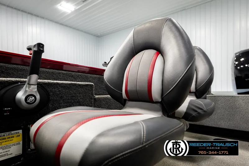 Slide: The Image of 2018 Ranger VS1882 WT boat interior with gray and red seats, throttle control, and Reeder-Trausch Marine logo. - 53