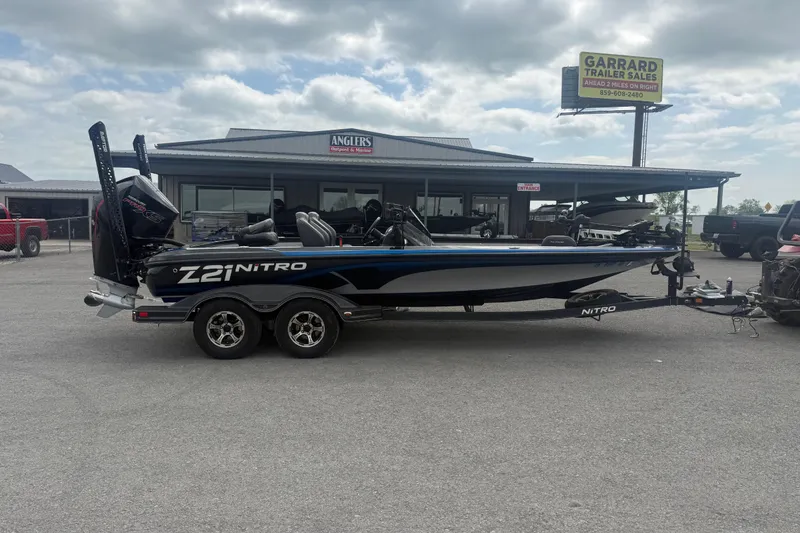 The Image of 2019 Nitro Z21 Pro boat parked outside dealership under cloudy sky. - 1