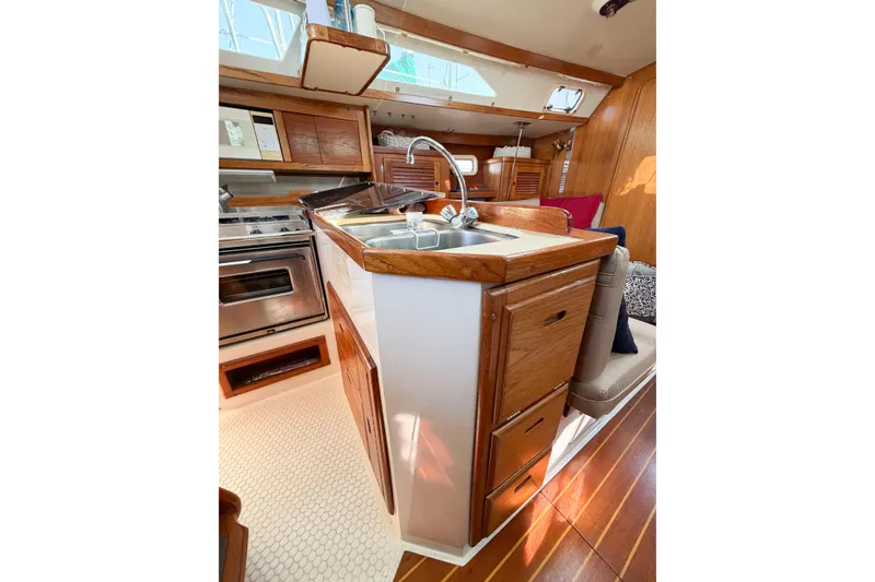 Slide: The Image of Interior of 1996 Catalina 36 MkII sailboat galley with wood cabinetry and stainless steel sink. - 32