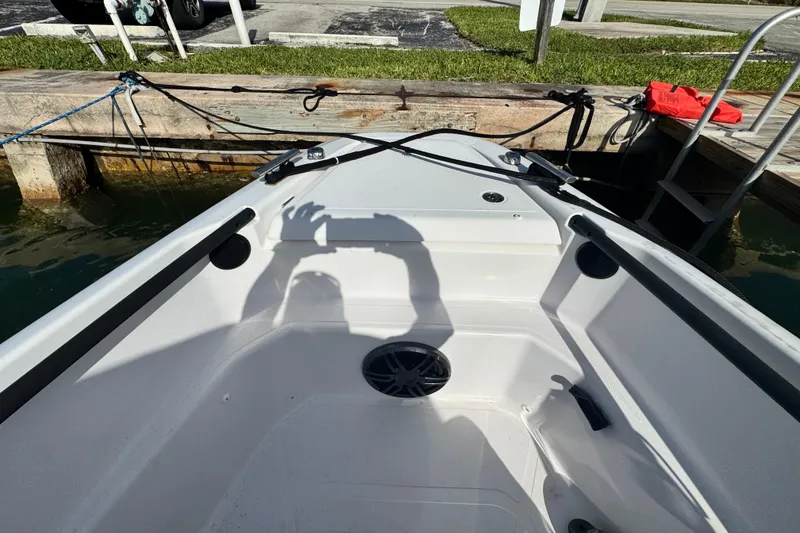 Slide: The Image of 2022 Axopar 22 T-Top boat docked, showing interior and shadow reflection. - 10