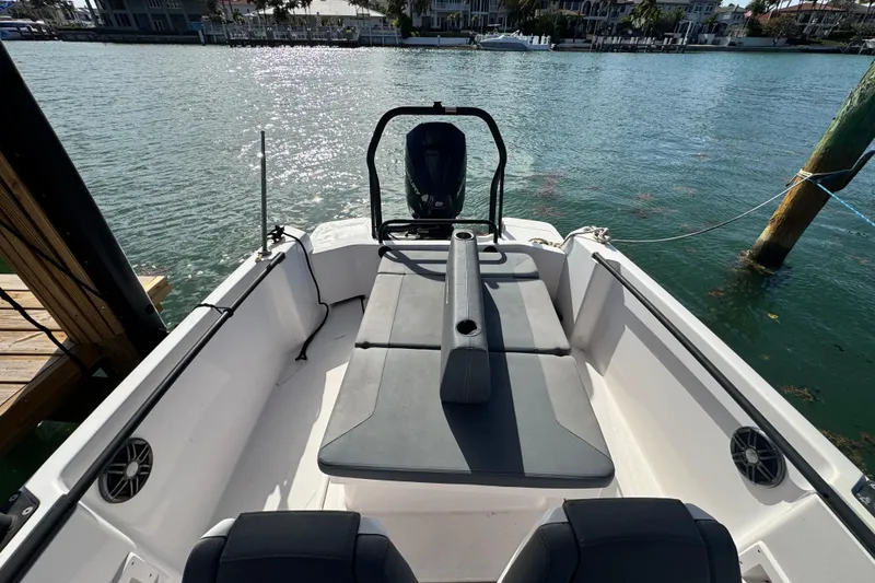 Slide: The Image of 2022 Axopar 22 T-Top boat interior with seating, docked by the water. - 14