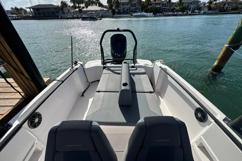 Slide: The Image of 2022 Axopar 22 T-Top boat interior with seating, docked by waterfront homes. - 15