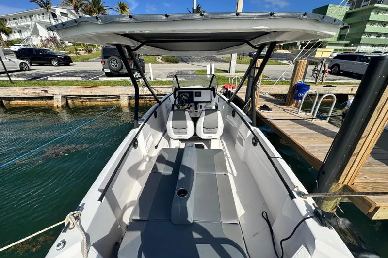 Slide: The Image of 2022 Axopar 22 T-Top boat docked, featuring sleek design and modern seating. - 3