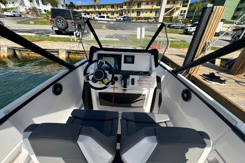 Slide: The Image of Cockpit view of 2022 Axopar 22 T-Top boat with modern steering and controls. - 5