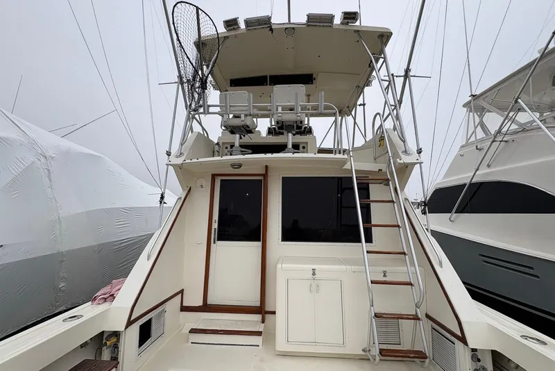 Slide: The Image of 1988 Viking 41 Convertible boat deck with coastal view and wooden steps. - 12