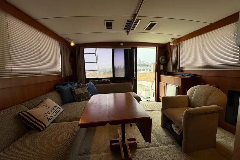 Slide: The Image of 1988 Viking 41 Convertible boat interior with helm, seating, and controls, docked near marshland. - 16