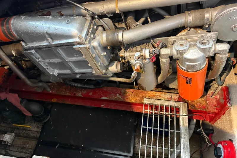 Slide: The Image of Engine compartment of a 1988 Viking 41 Convertible boat, featuring mechanical components and an orange oil filter. - 29