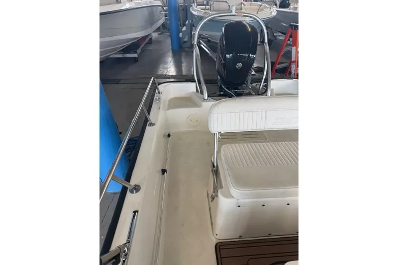 Slide: The Image of 2015 Boston Whaler 170 Montauk boat interior with seating and motor in a showroom. - 8