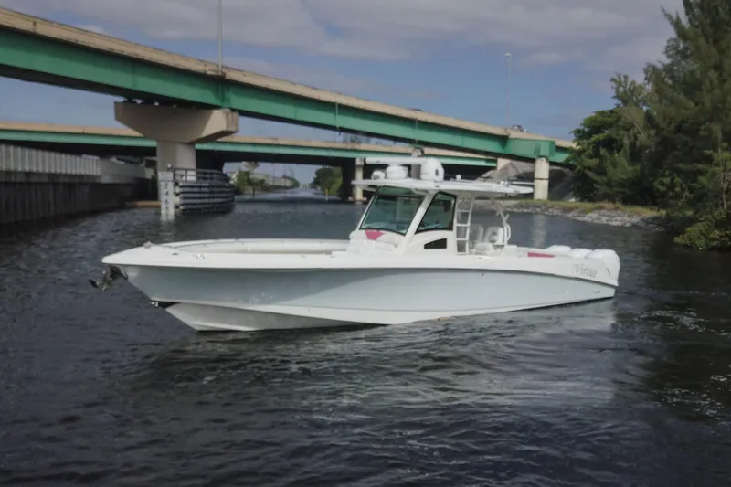 Slide: The Image of 2012 Boston Whaler 370 Outrage boat cruising under a bridge on a calm waterway. - 3