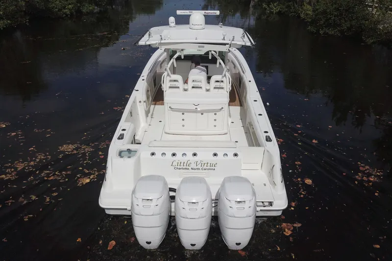 Slide: The Image of 2012 Boston Whaler 370 Outrage boat with triple engines on a calm waterway. - 4
