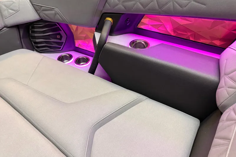 Slide: The Image of 2024 Nautique Super Air Nautique G25 Paragon interior with ambient lighting and cup holders. - 11