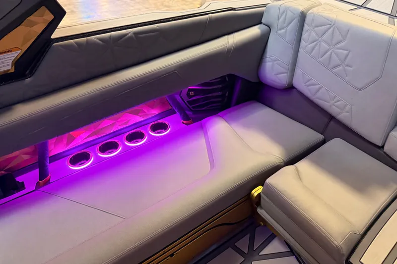 Slide: The Image of 2024 Nautique Super Air Nautique G25 Paragon interior with illuminated seating and cup holders. - 17