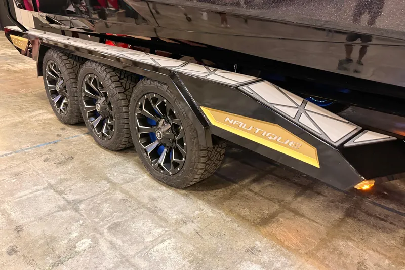 Slide: The Image of 2024 Nautique Super Air Nautique G25 Paragon trailer with stylish black wheels and branding. - 5