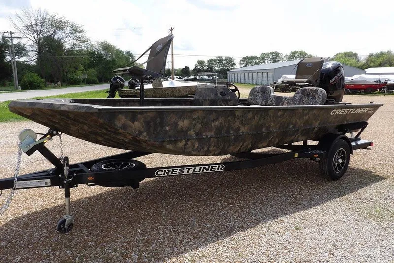 Slide: The Image of 2026 Crestliner 1860 Retriever SC boat on trailer, camo design, parked outdoors. - 3