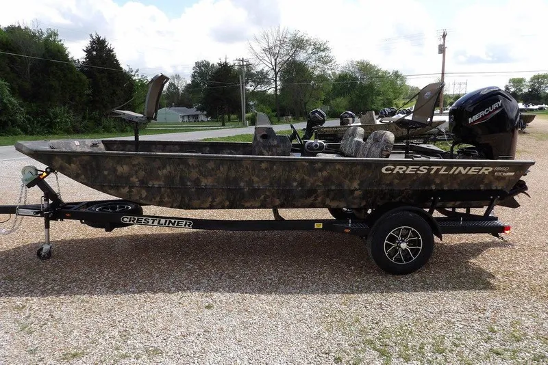 Slide: The Image of 2026 Crestliner 1860 Retriever SC boat on trailer, camo design, parked outdoors. - 7